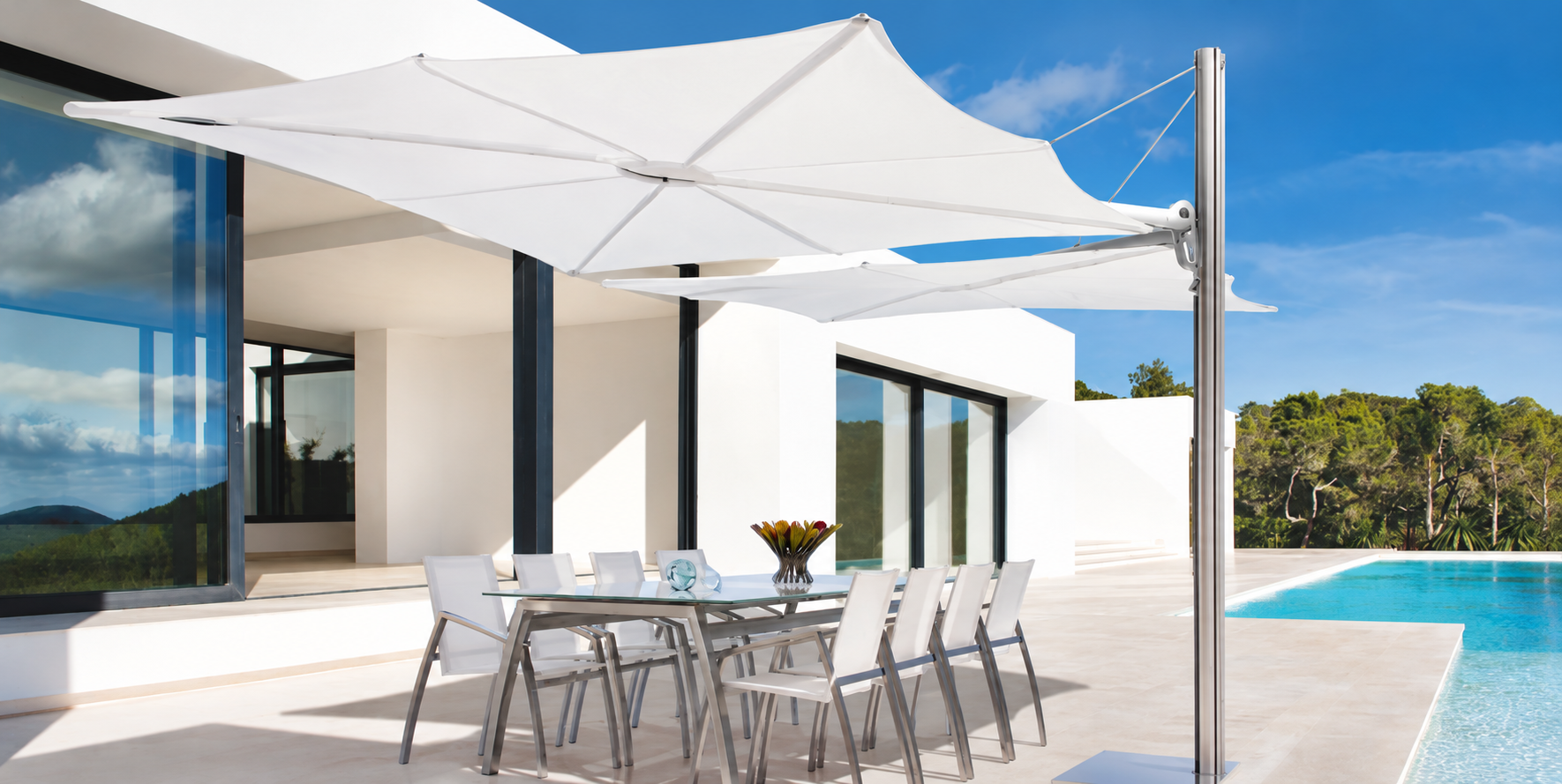 White cantilever umbrellas shading a poolside dining terrace