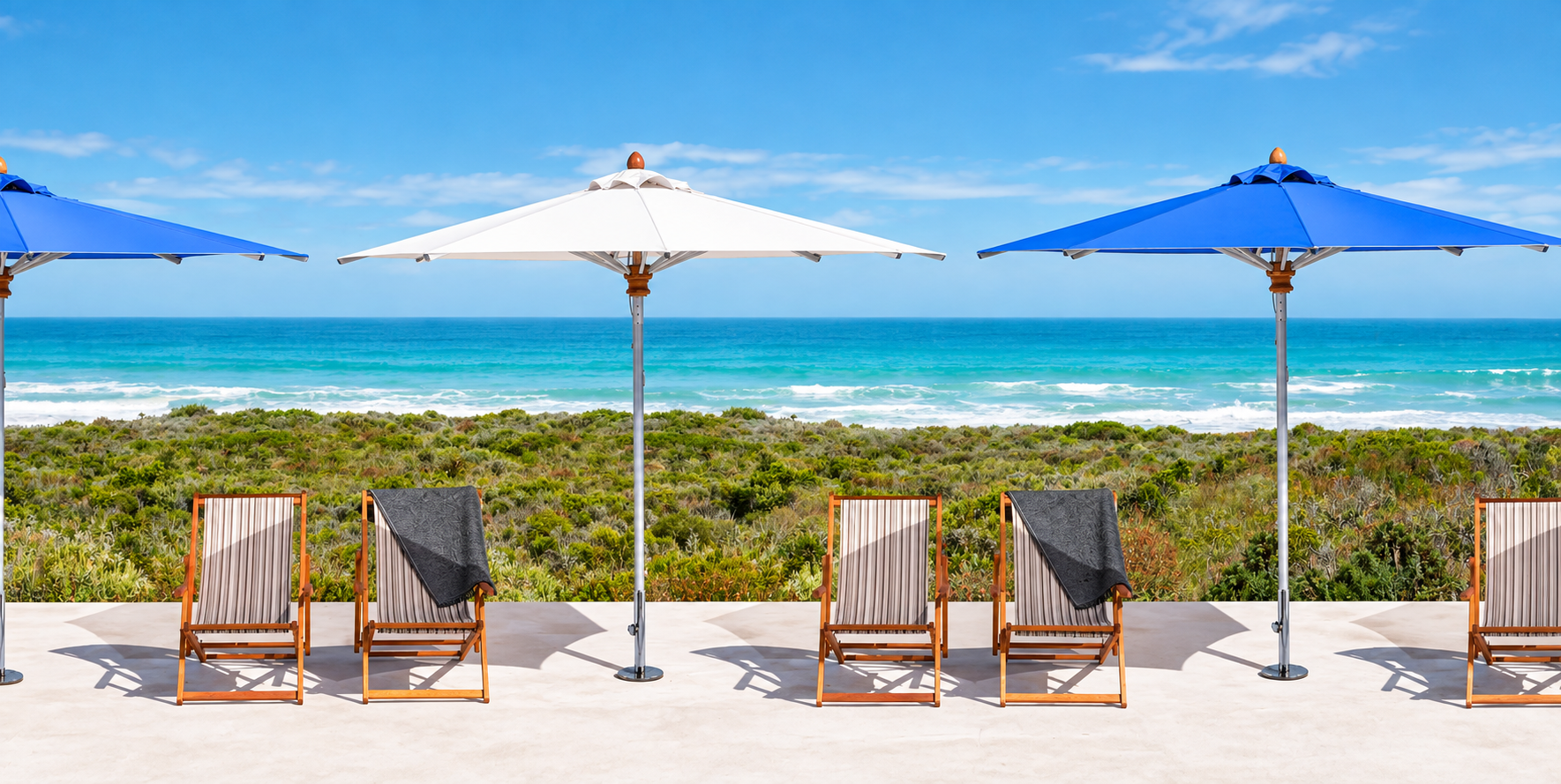 Blue and white market umbrellas along a coastal pool deck